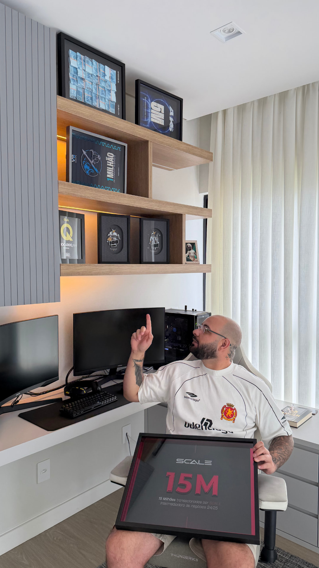 Matheus no escritório com a placa de 15M